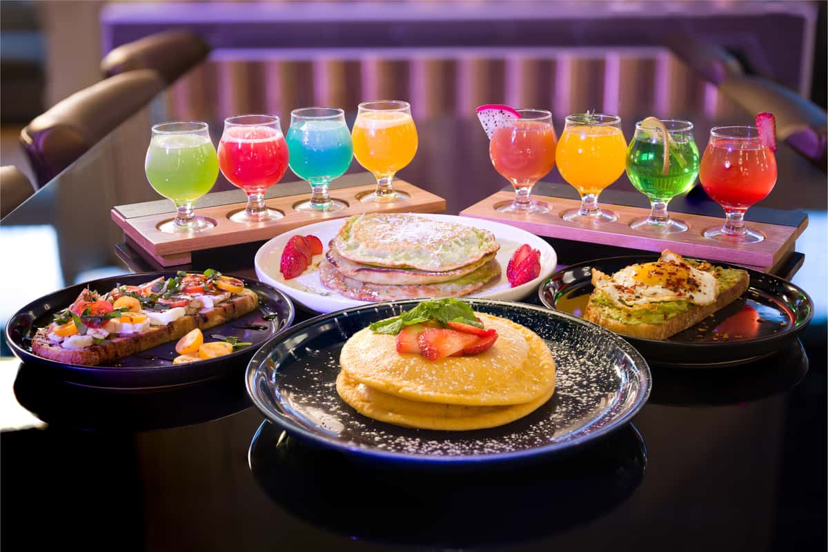 Beehive brunch spread with pancakes, avocado toast, tomato burrata toast and colorful cocktail flights in Downtown Dallas