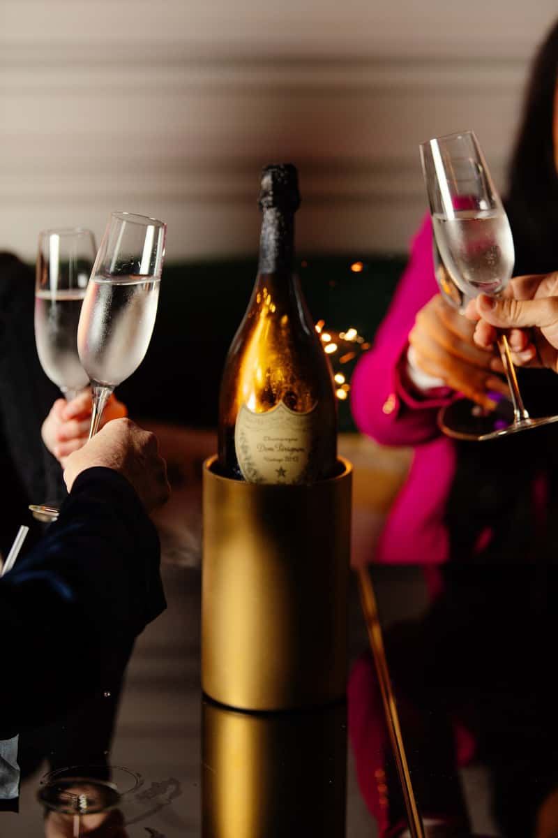 Guests raising champagne glasses during bottle service at Beehive bar and lounge in Downtown Dallas