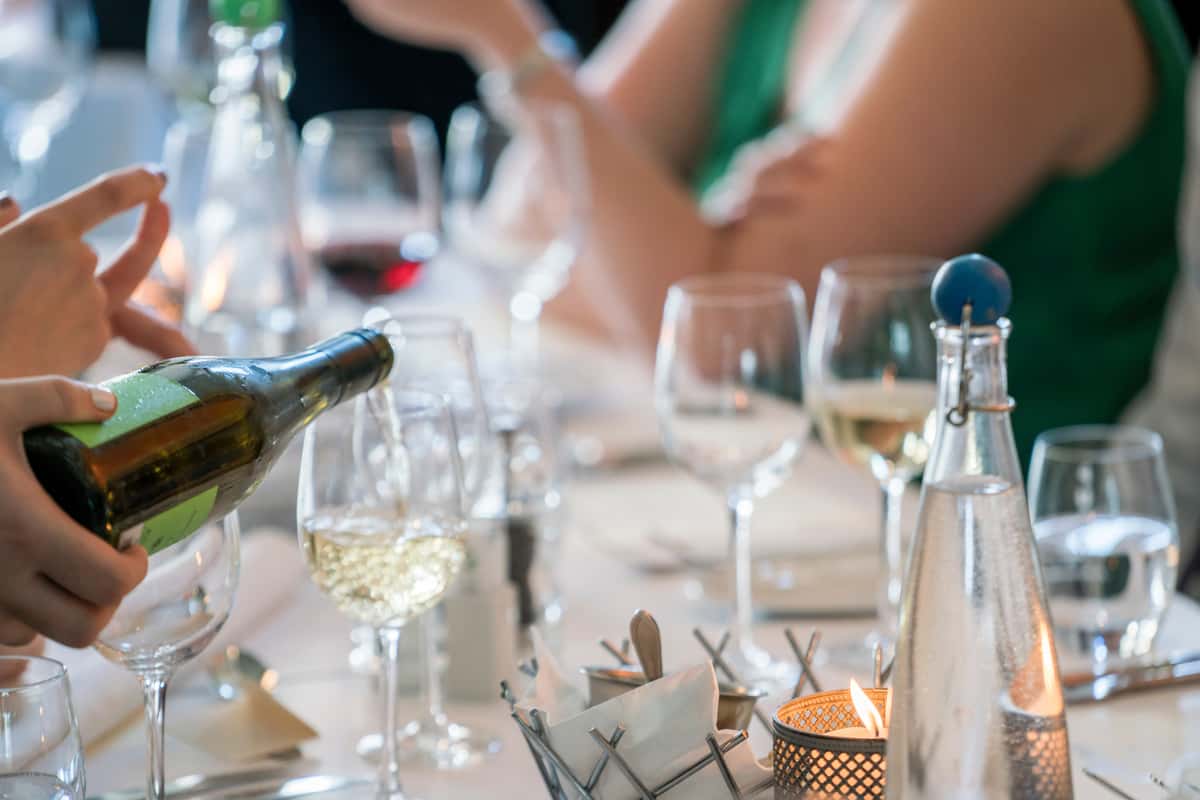pouring wine at the table with guests