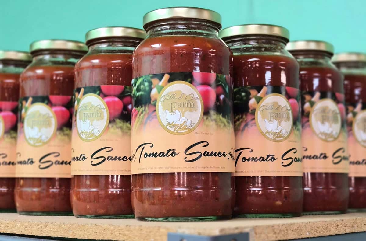 bottled salad dressings and marinades in various flavors lined up on a wooden shelf