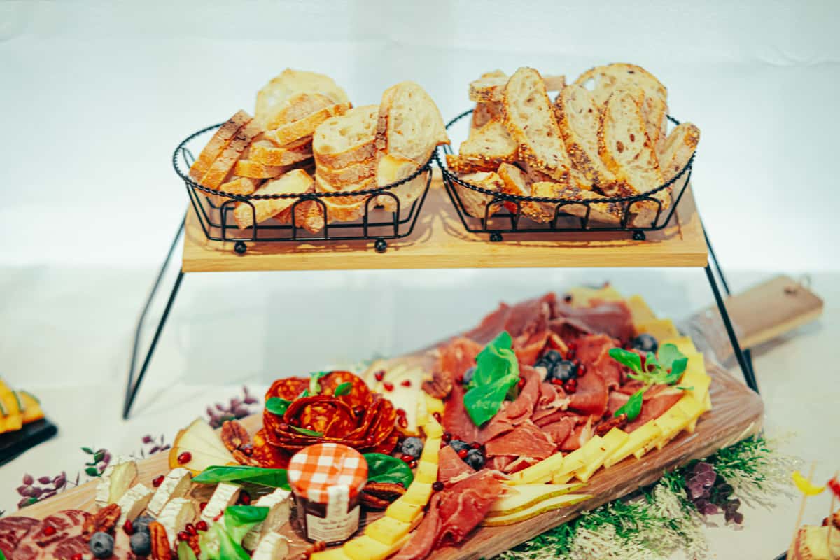 A rustic charcuterie board with assorted meats, cheeses, and artisan bread on a wooden table.