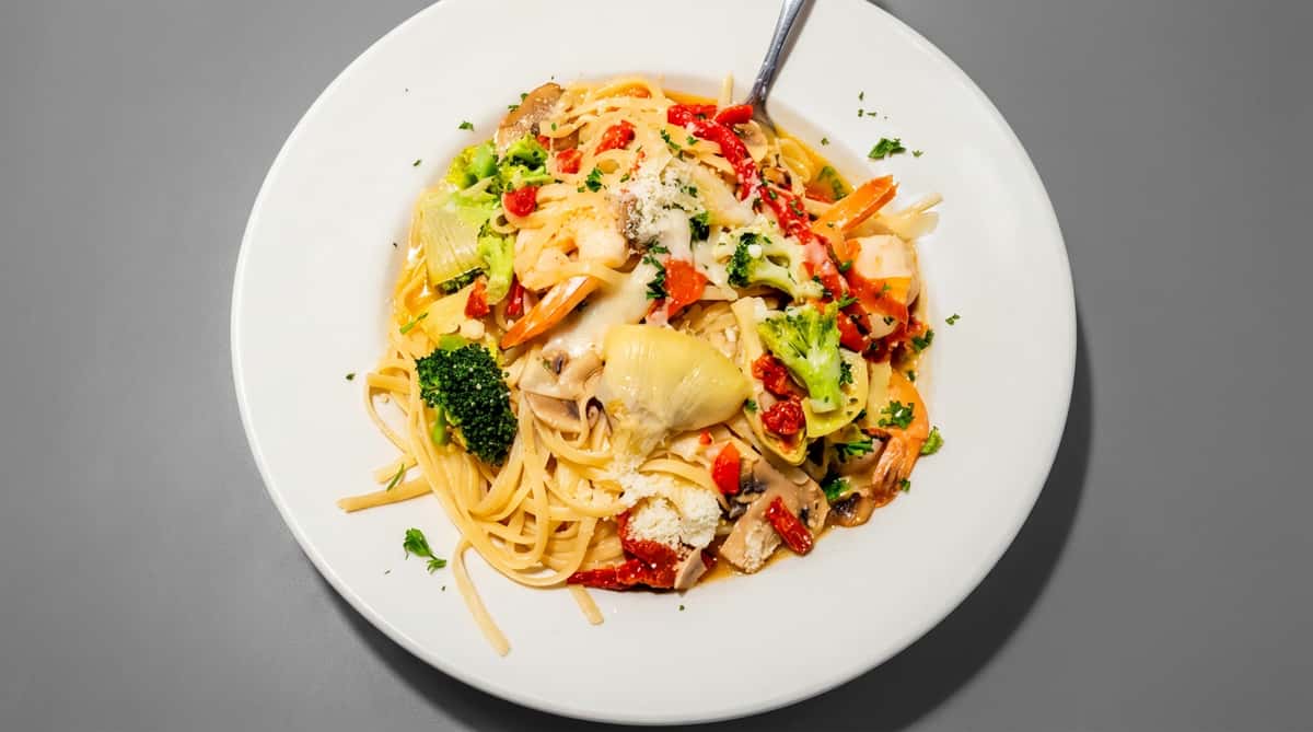Linguine primavera with shrimp, broccoli, artichoke hearts, sun-dried tomatoes, mushrooms, and parmesan cheese.