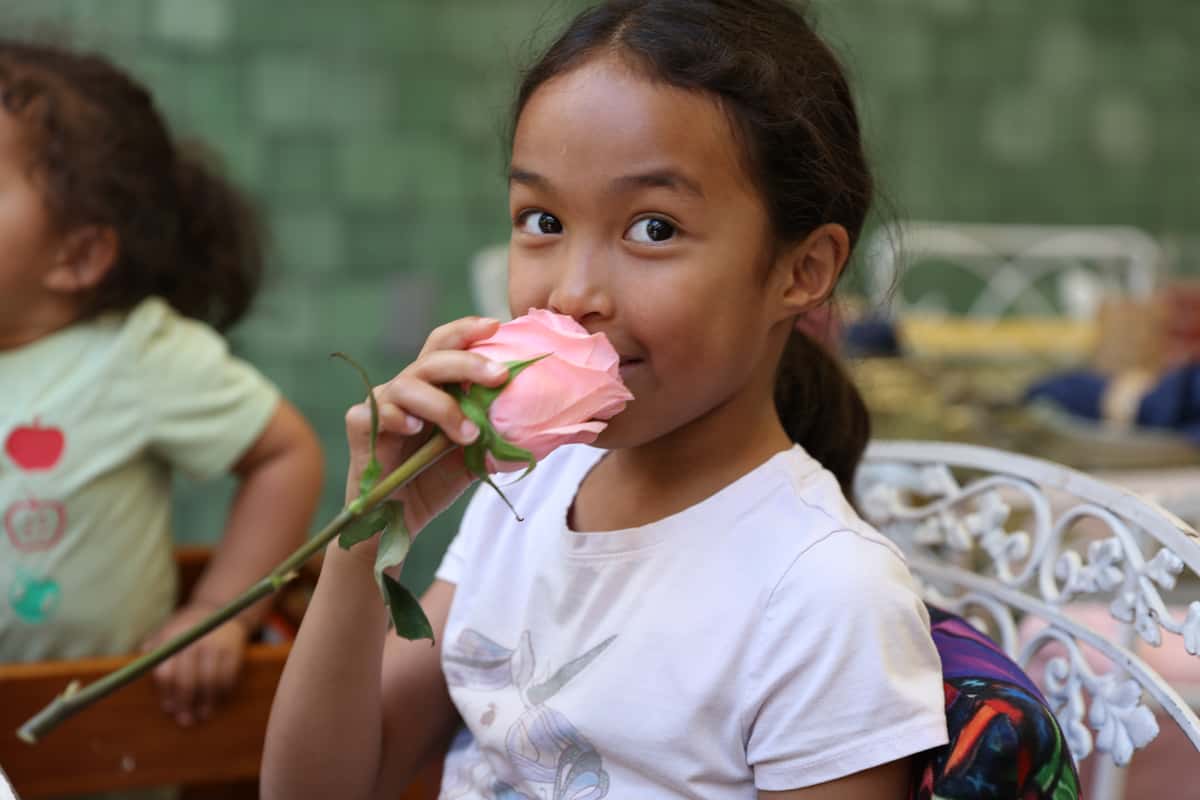 kid smelling flower