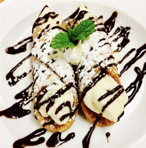 two cannolis with chocolate drizzle