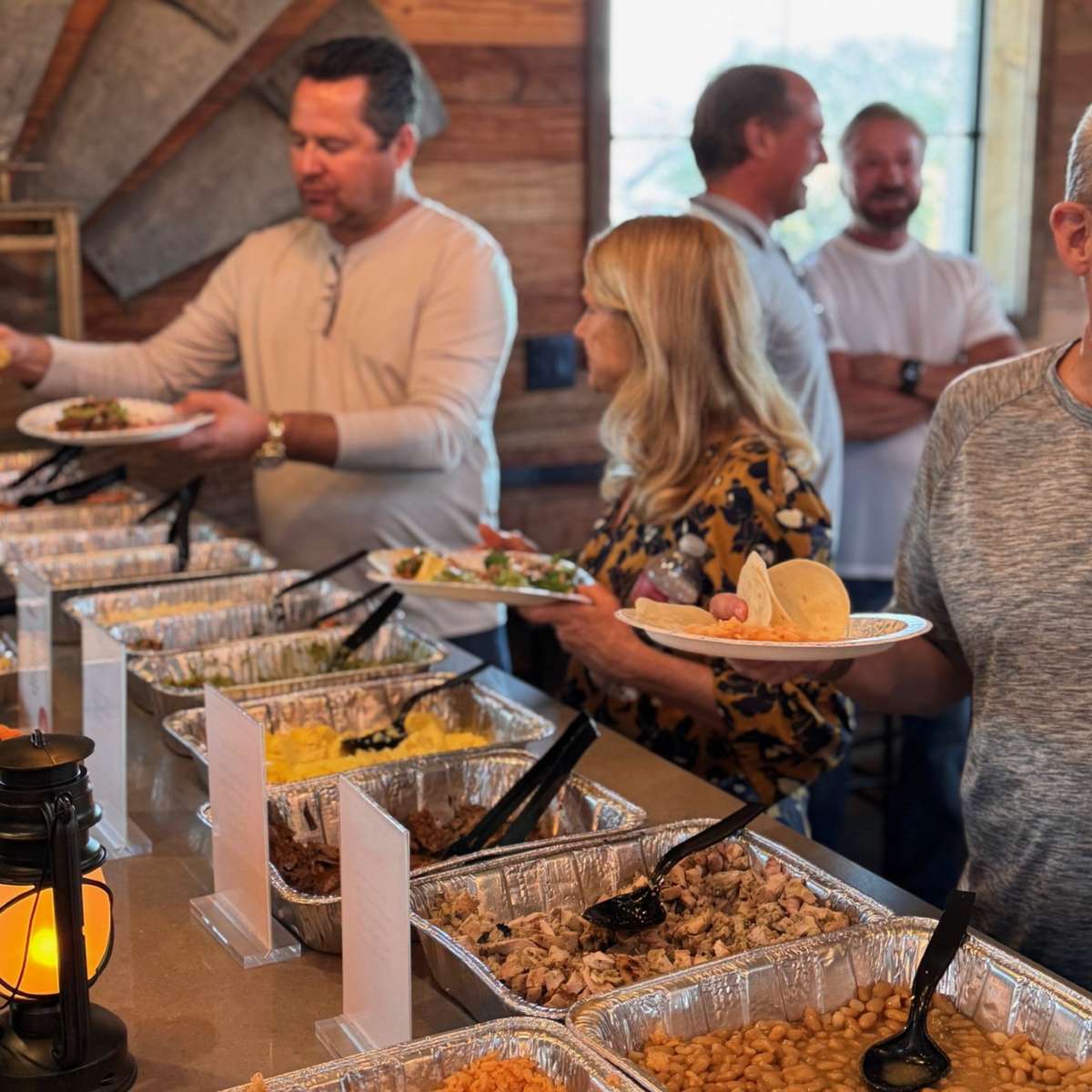Guests serving themselves from a Two Step Taqueria taco and bowl catering bar in Austin
