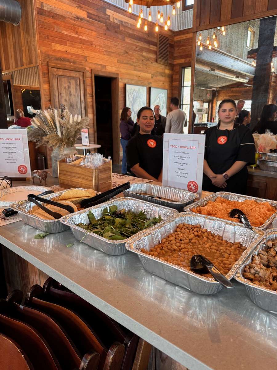 Two Step Taqueria taco and bowl catering setup with staff and buffet trays in Austin
