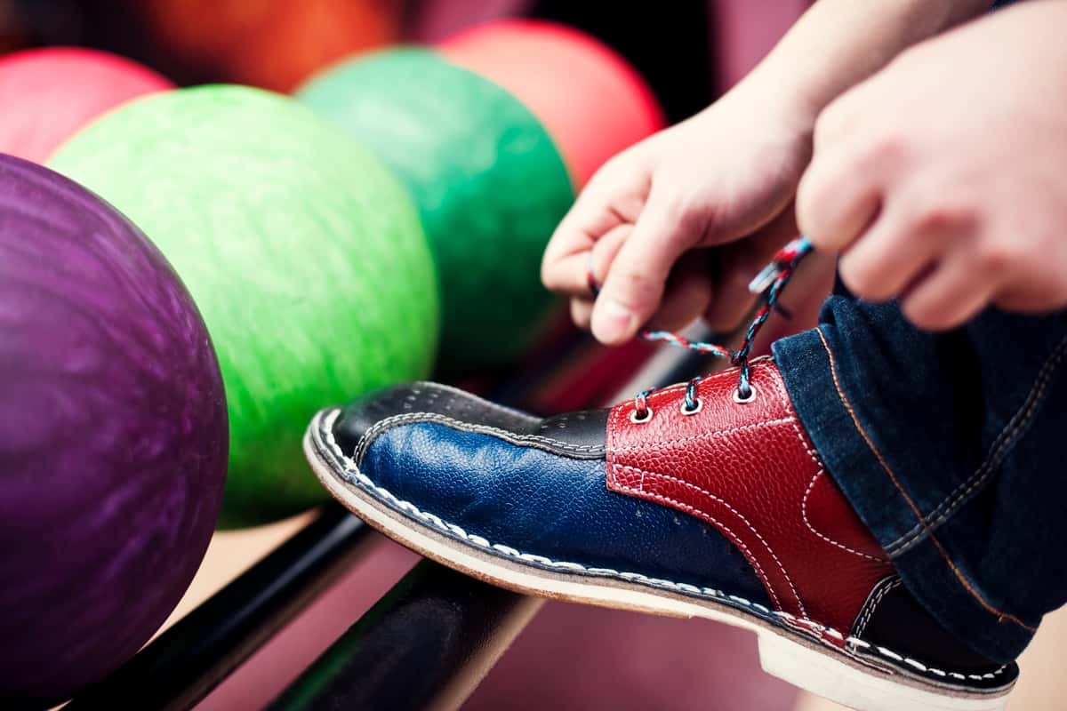 person tying bowling shoes