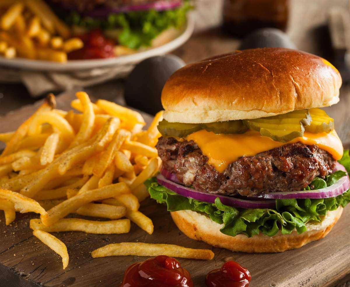 Cheeseburger with pickle, onion, lettuce. Fries with ketchup on the side.