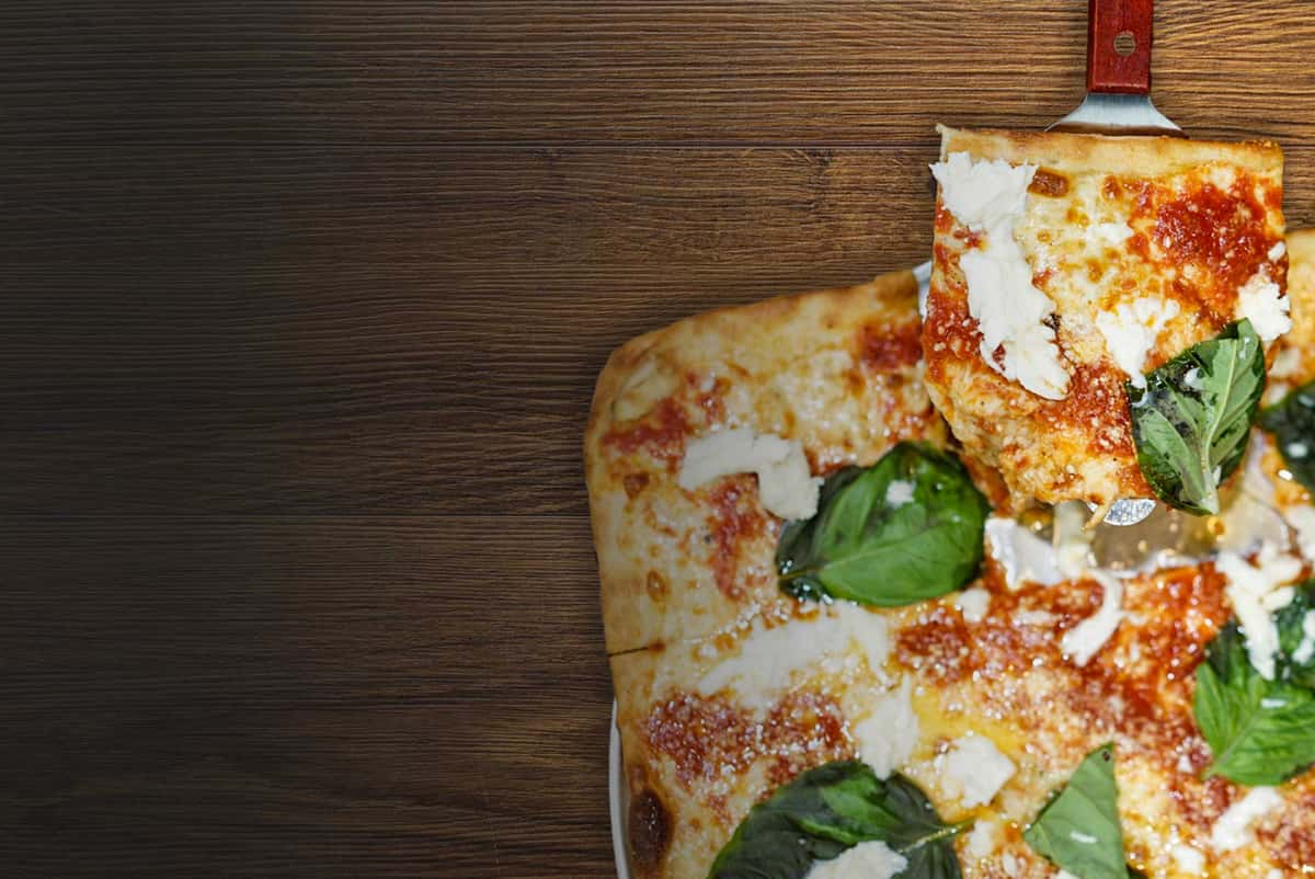 square pizza with basil leaves