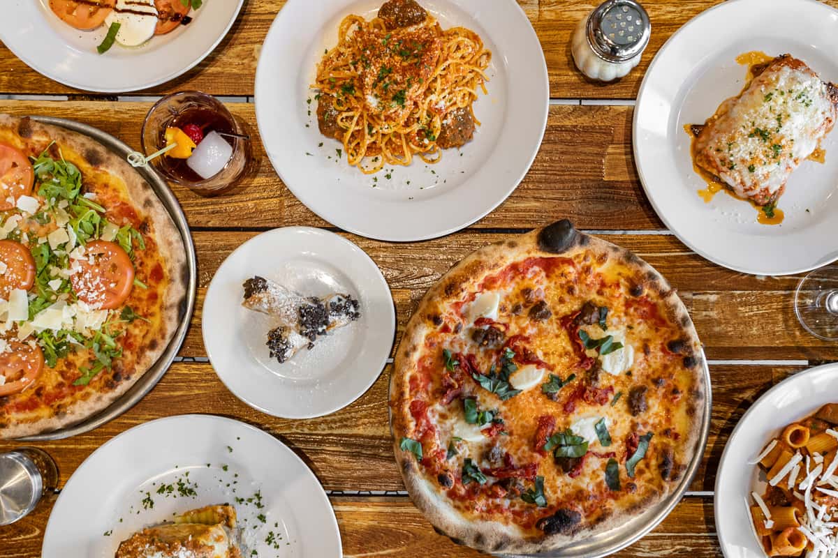 Multiples pizzas and italian dishes in a table