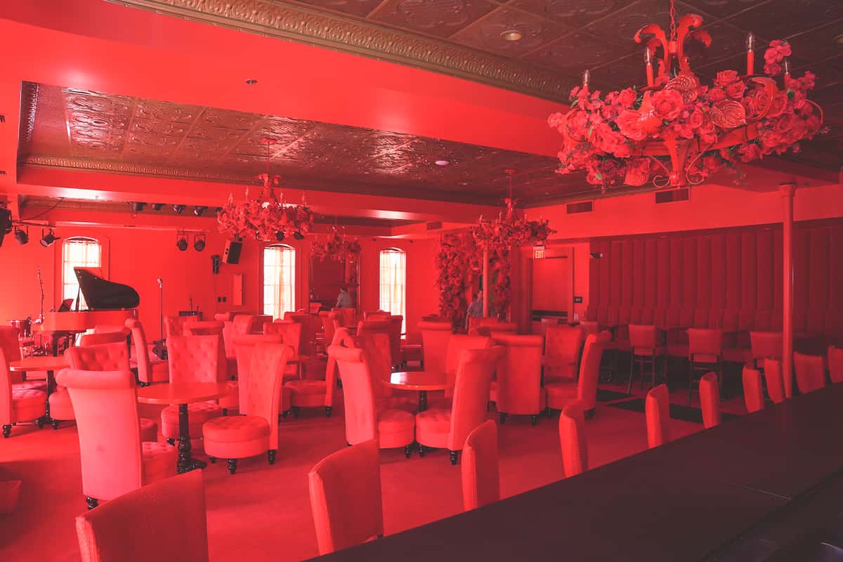 Hall with multiple tables and chairs with red lighting