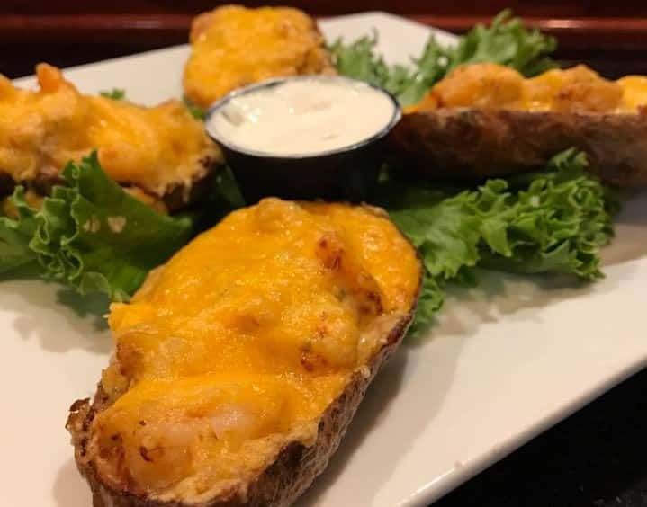 Potato skins with bacon and cheese on top with a side of sour cream 
