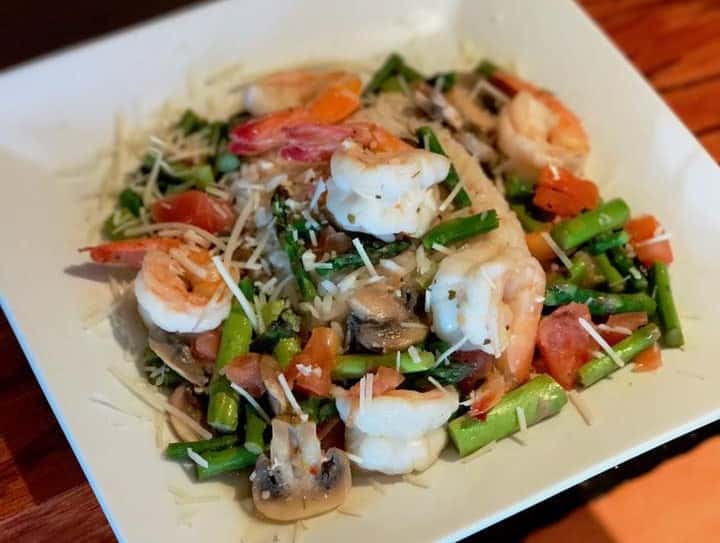 Asparagus salad with shrimp, tomatoes, mushrooms, and parmesan cheese sprinkled on top