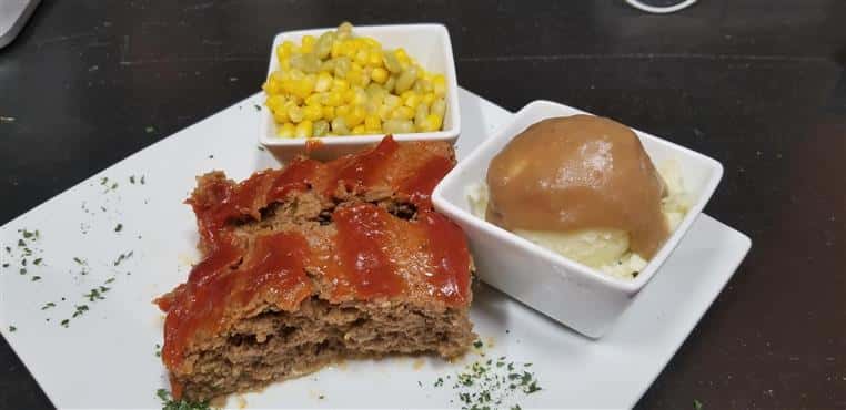 Meatloaf with side of corn and mashed potatoes with gravy