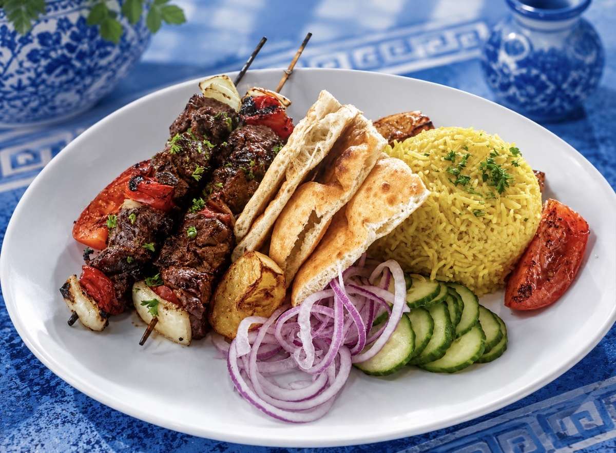 Meat skewers with pita bread, rice and grilled veggies
