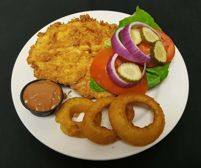 Country fried steak with onion rings and dipping sauce at The Locale
