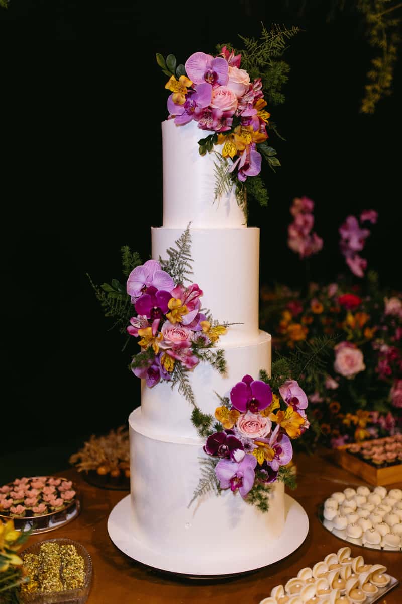tall wedding cake with purple flowers