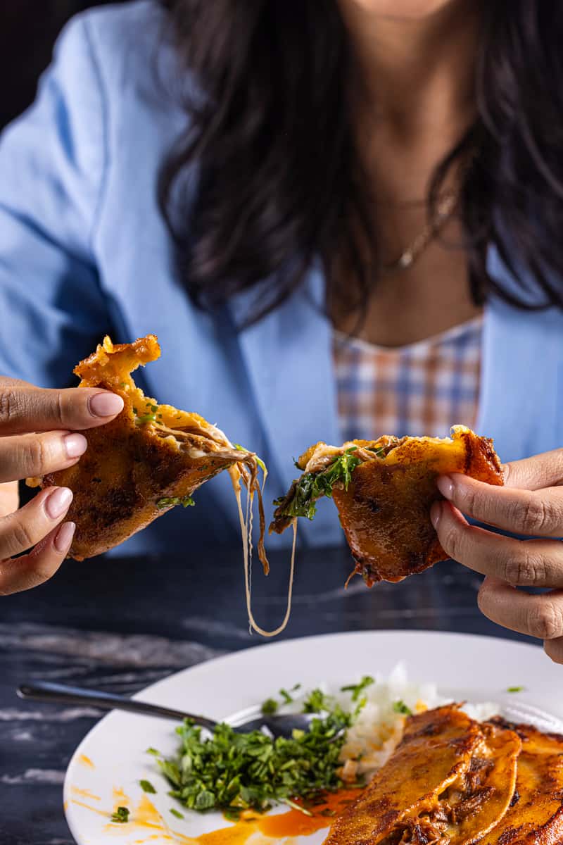 Guest pulling apart a birria taco