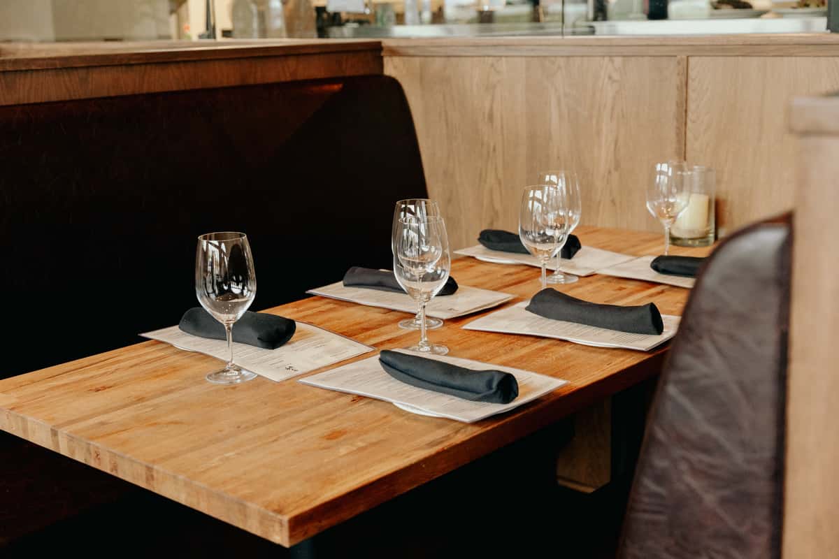 Booth seating with menus, silverware and glassware on top of the table