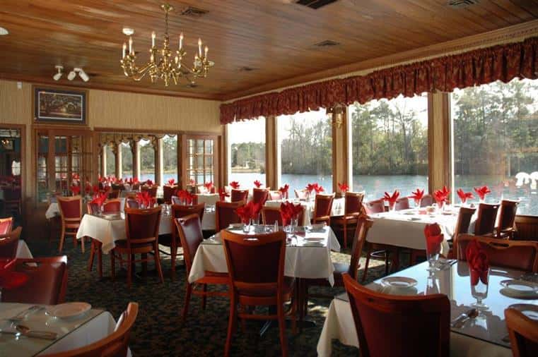 interior dining area of the chestnut hill with multple tables next to an open window showcasing the lake