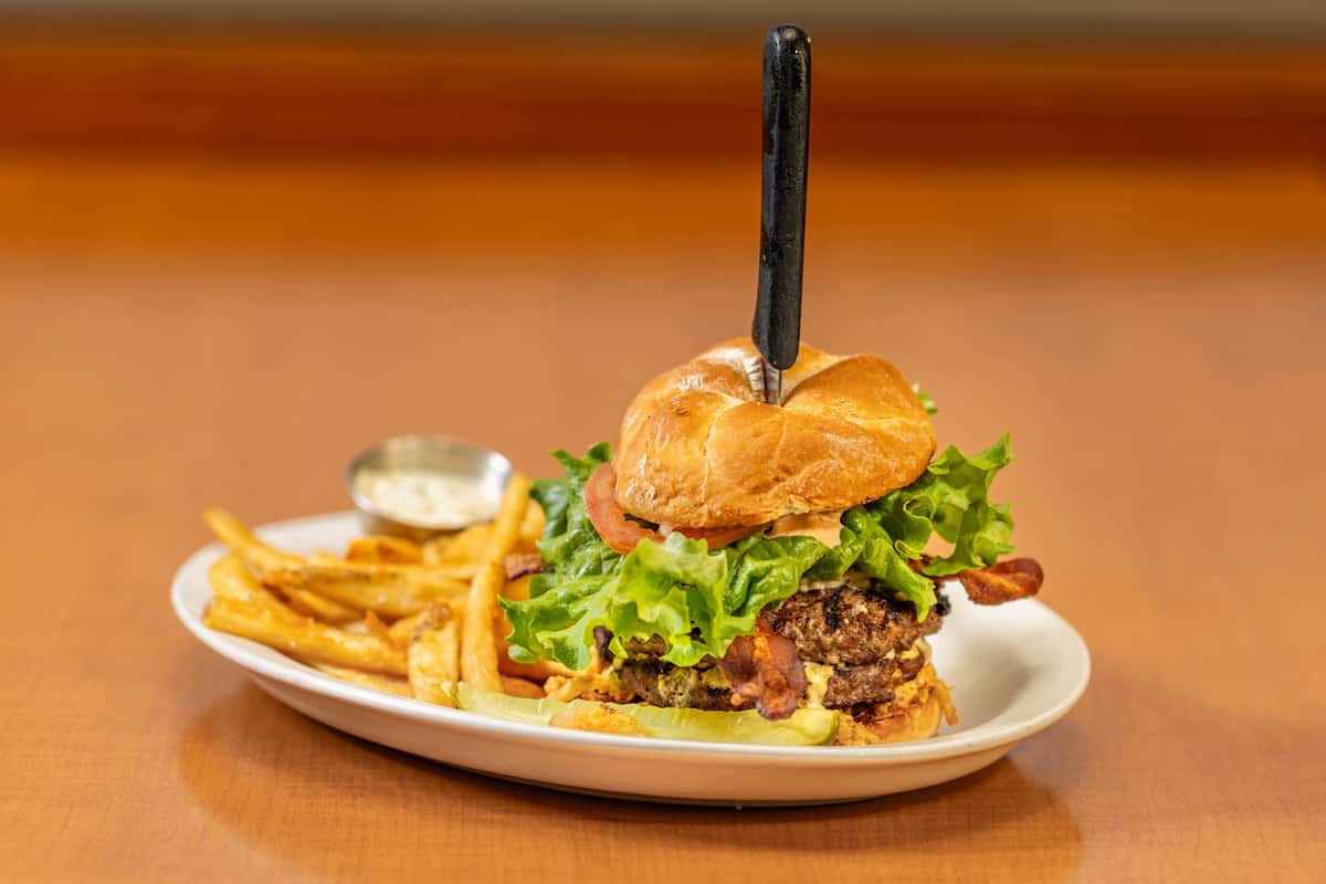 The legendary Sasquatch Burger at Collector's Choice Restaurant in Snohomish, featuring a thick beef patty, crispy bacon, and fresh toppings.
