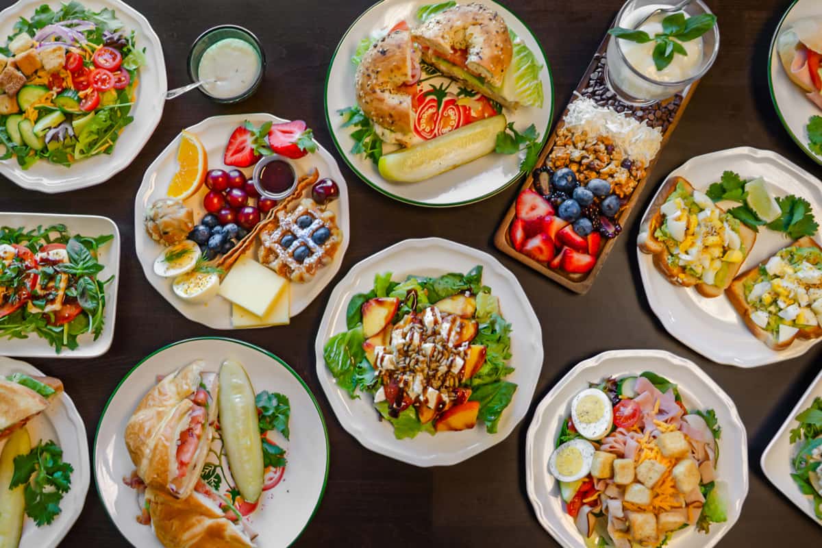 Vibrant brunch spread featuring fresh garden salads, gourmet sandwiches, fruit-topped waffles, yogurt parfait with granola and berries, and open-faced avocado toast — ideal for health-conscious cafés or farm-to-table brunch restaurants.