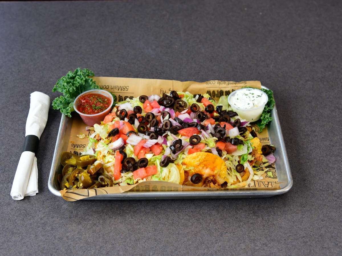 Corn tortilla chips loaded with jack & cheddar cheese and BBQ marinated pulled pork. Topped with fresh chopped tomatoes, lettuce, black olives & onions. Served with jalapenos, sour cream, and salsa.