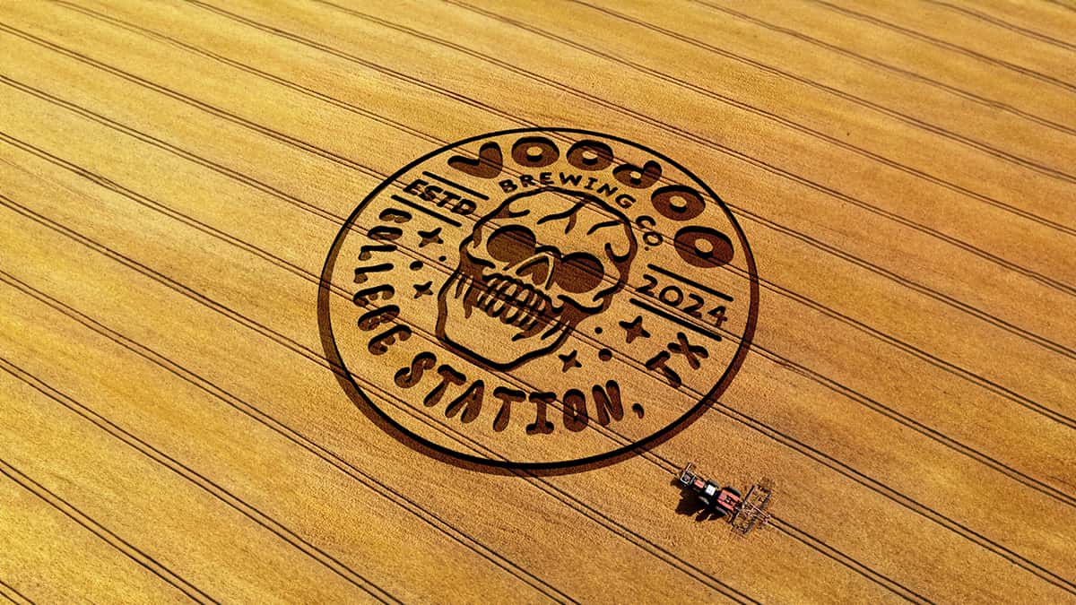 Voodoo Brew Pub College Station, TX logo cut into a corn field with a combine