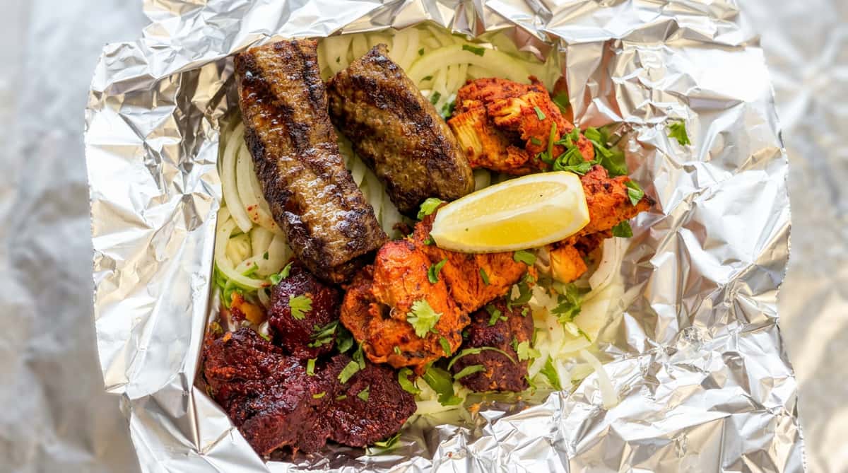 Mediterranean kabob platter at Sivas Tavern featuring grilled kebabs, rice, salad, and fresh lemon garnish