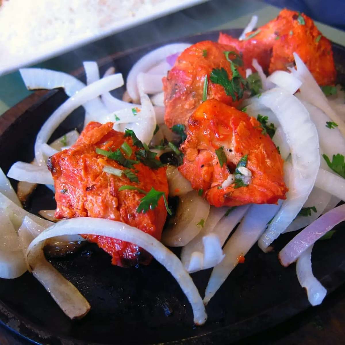Seasoned curried meat pieces served with onion slices