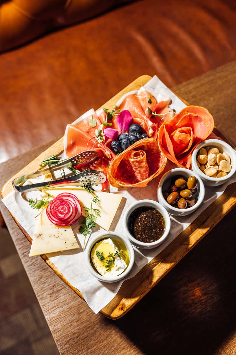 Charcuterie board with a variety of meats, cheeses and nuts