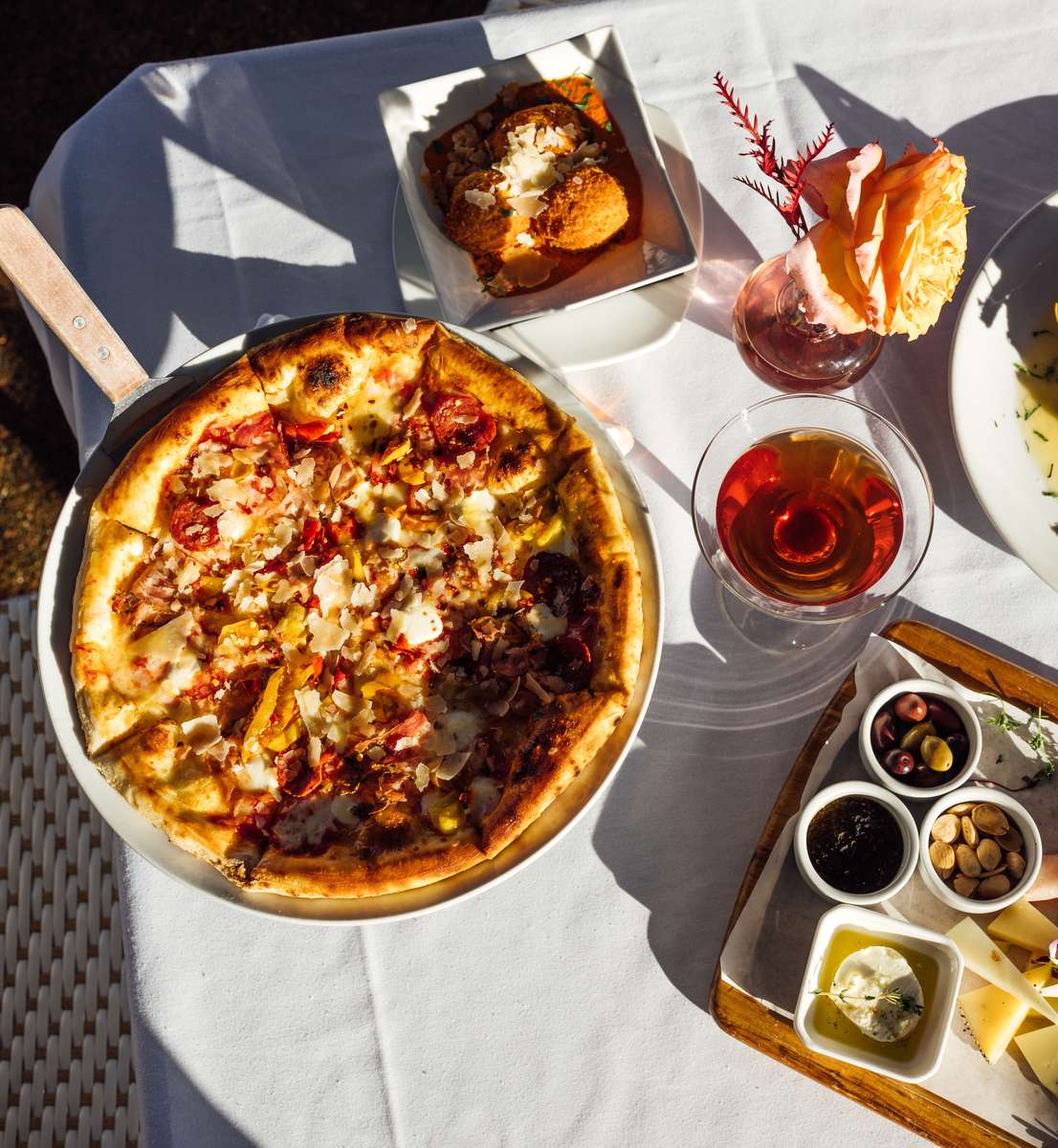 Pizza and drinks on a white tablecloth