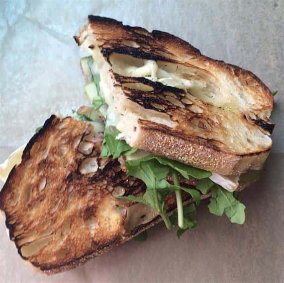 arugula and pickles with cheese on fresh toasted bread