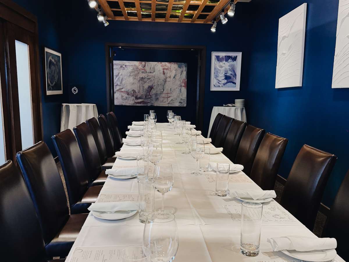 The Vineyard Room offers a sleek, glass-lined ceiling and art-filled walls, ideal for seated dinners up to 20 guests in Louisville's Westport Village.