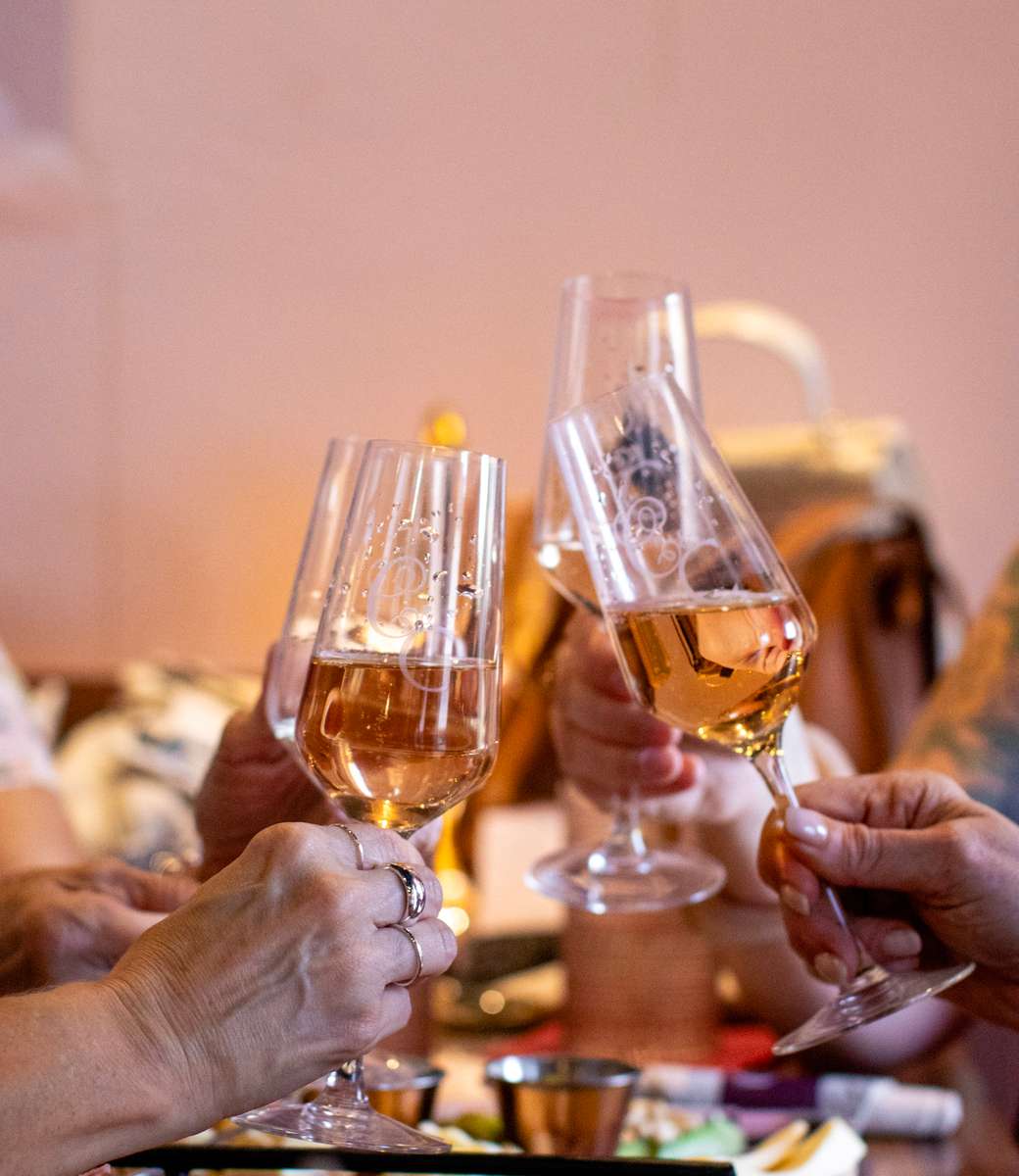 Raising four champagne glasses