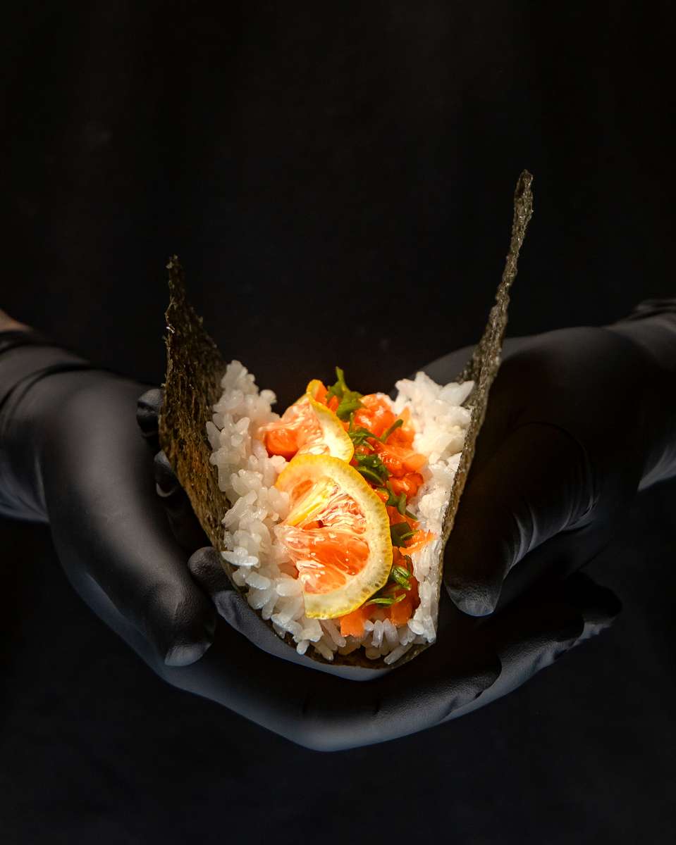 a photo of black gloves holding a hand roll