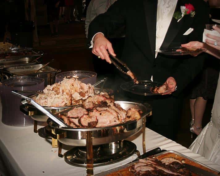 Catering sternos with meat next to meat on carving board at wedding event
