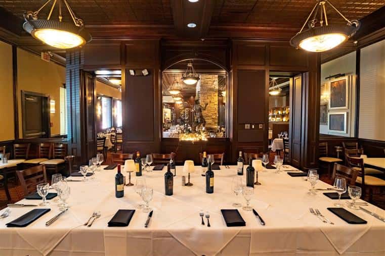 inside the restaurant, in the wine room, photo of a set table with wine bottles and place settings