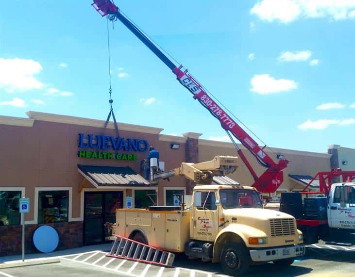 large business sign being installed in front of the store front