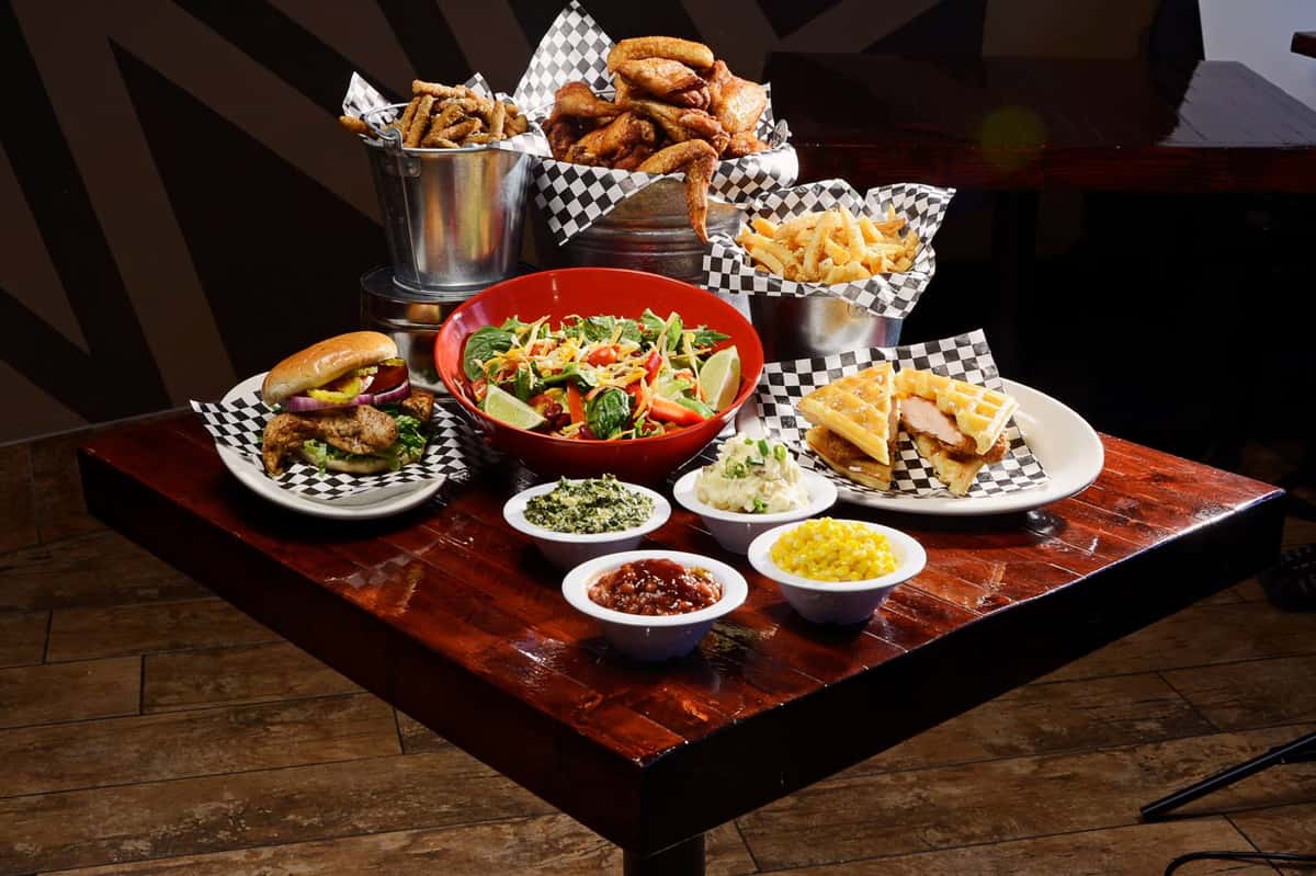 sandwiches, wings, and side dishes on a table