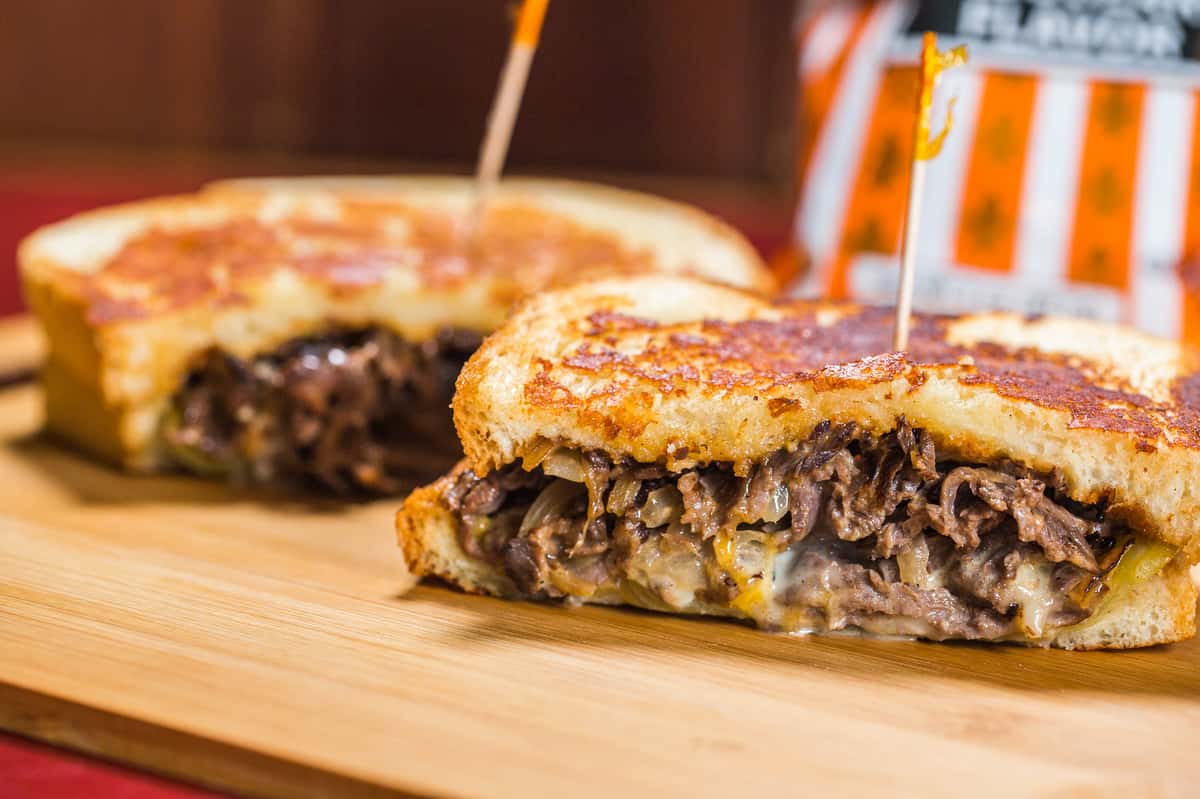 Marinated tri tip served on parmesan crusted sourdough with a blend of cheddar and pepper jack cheeses, drizzled with southwest sauce, grilled onions, and an Ortega chile.