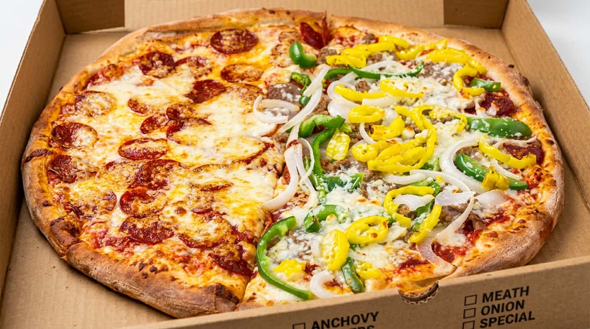 Half pepperoni, half sausage pizza with banana peppers, green peppers, and onions in a cardboard box.