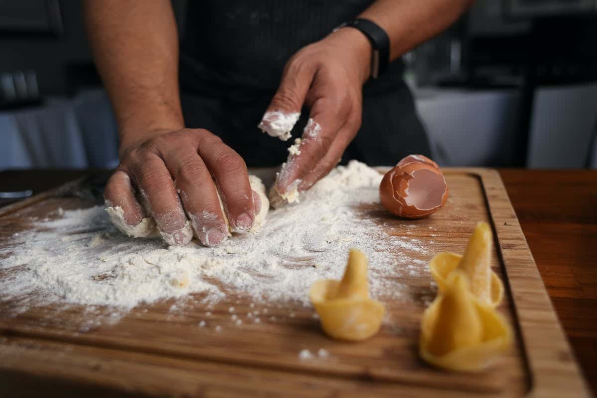 person making pasta dough