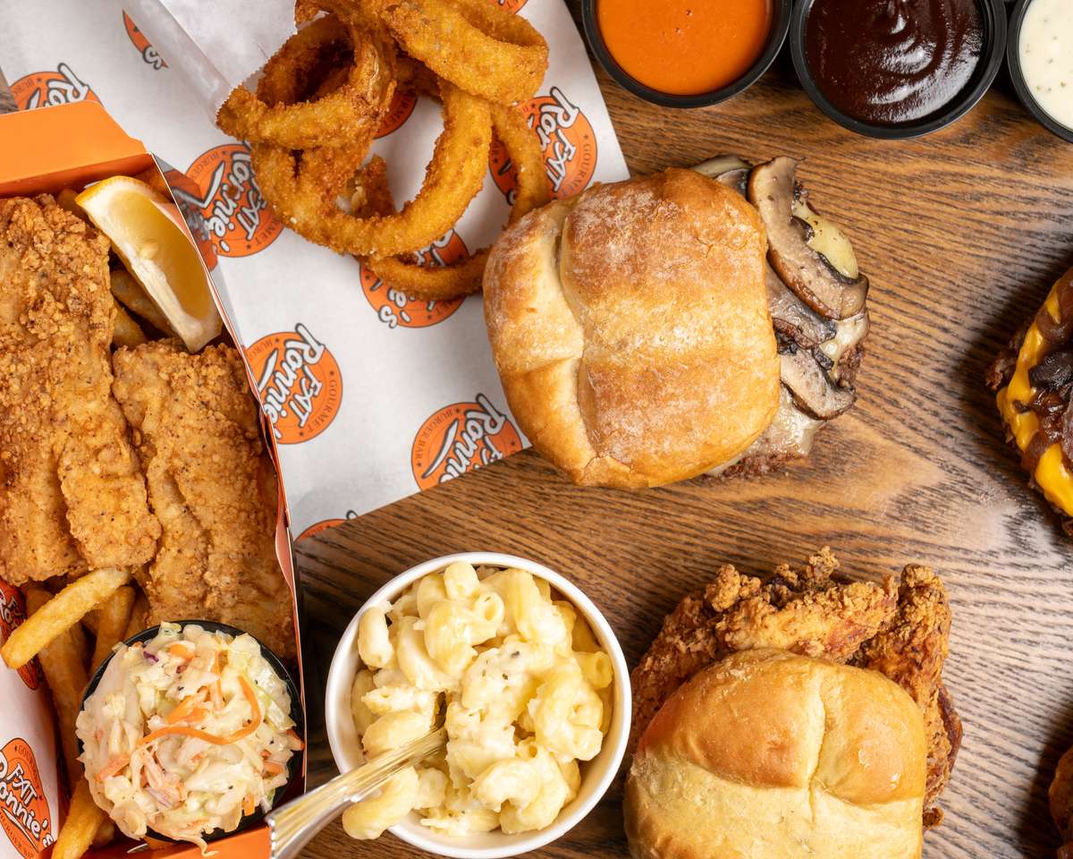 Crispy fried chicken meal with biscuit, fries, and dipping sauces in a takeout box