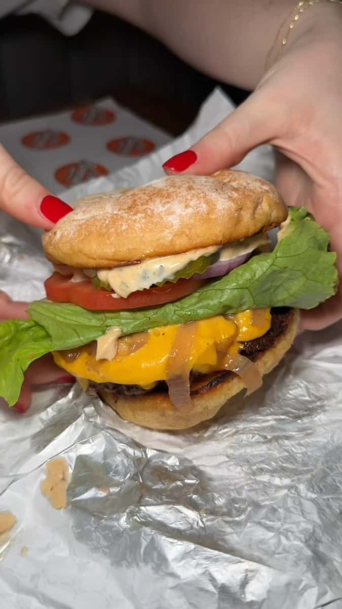 About to pick up a cheeseburger on tinfoil wrap