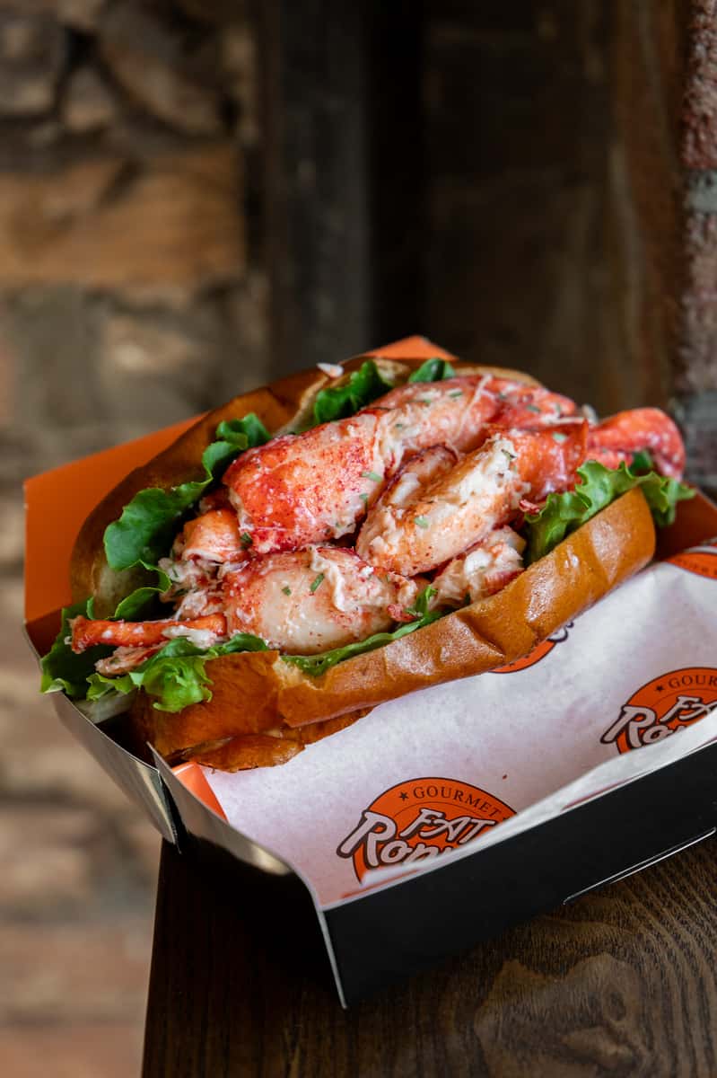 Close-up of a lobster roll overflowing with seasoned lobster