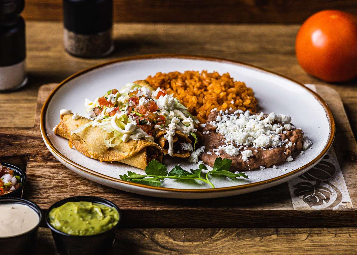 3 Chicken Flautas, Lettuce, Tomato, Oaxaca Cheese, and Sour Cream, Served with Rice and Beans
