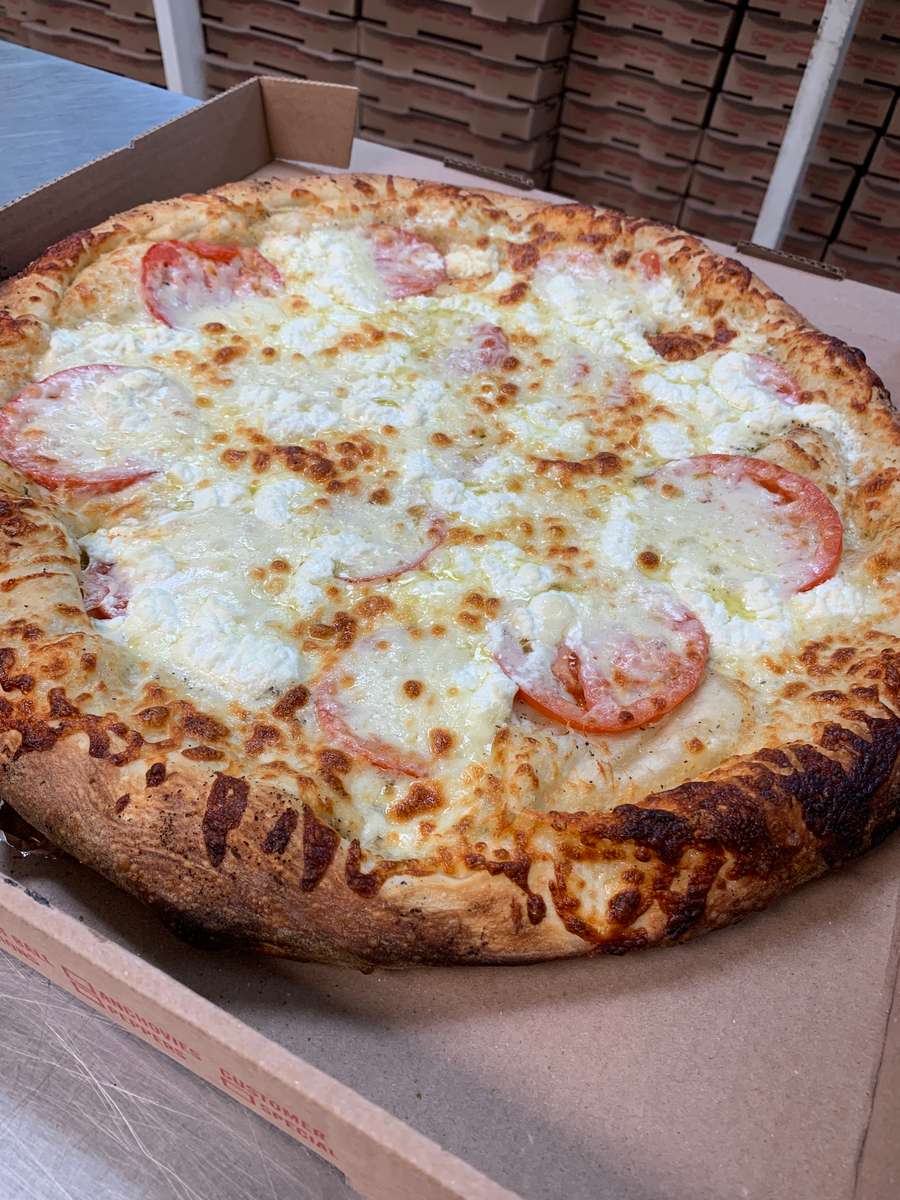Large tomato and cheese pizza with a thick, golden-brown crust in an open cardboard box.