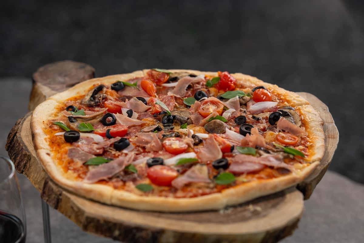 freshly-baked-gourmet-pizza-with-toppings-on-a-rustic-wooden