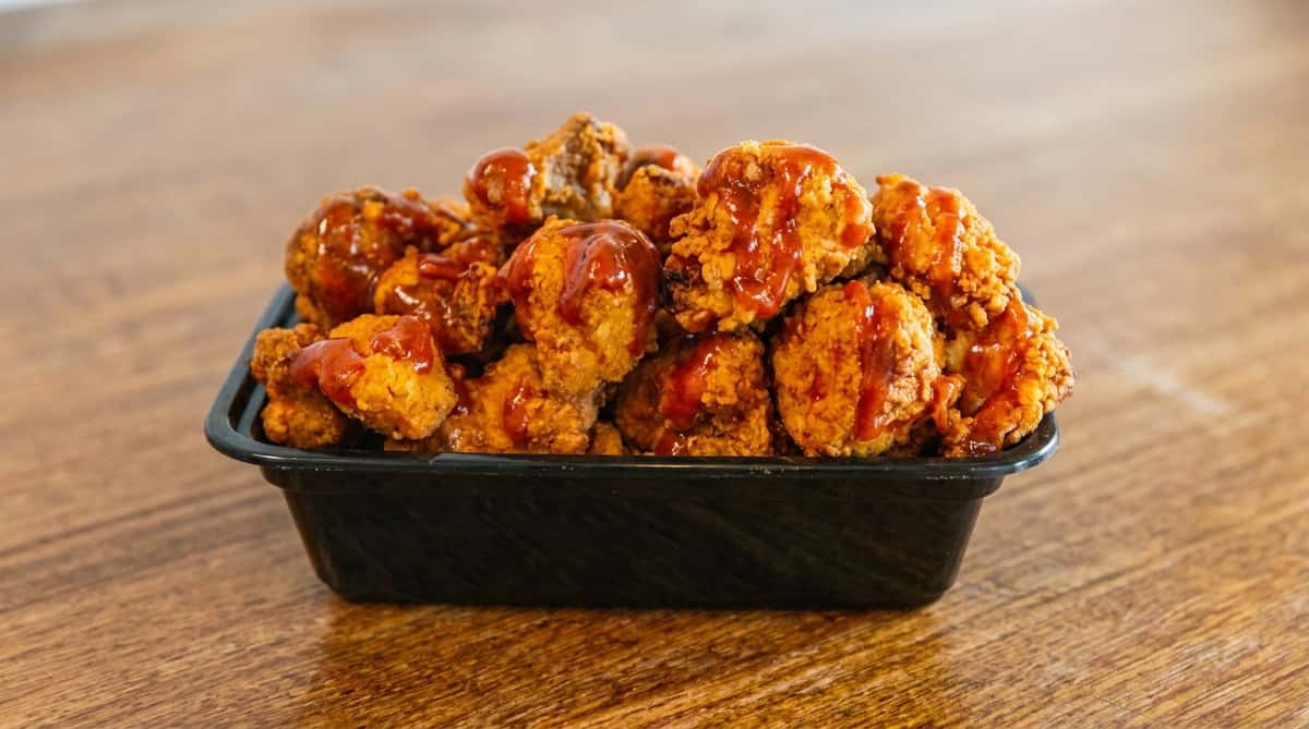 Hickory-smoked BBQ chicken wings tossed in sauce at Fainmous BBQ in Pearland TX
